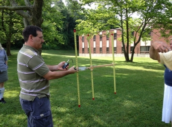 Scott using an antenna made with a measuring tape, to do an activity called Fox Hunting. It is and way to find a hidden transistor using radio frequencies.