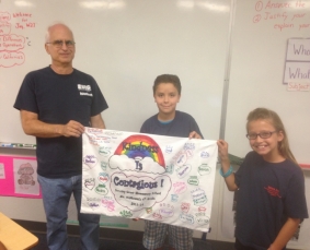 Students present Jay with our flag for him to take to Banaba on his trip this October. We hope our kindness IS contagious!